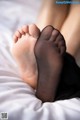 A close up of a person's feet in black stockings.