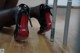 A pair of black and red high heels on a wooden floor.