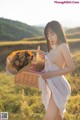 A woman in a white dress holding a basket of flowers.