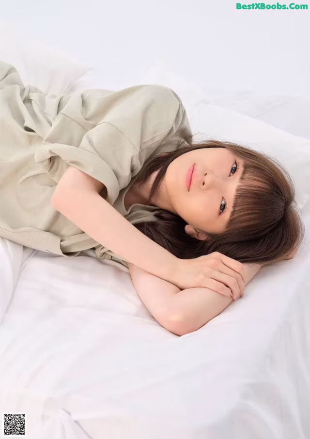 A woman laying on a bed with her head on the pillow.