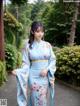 A woman in a blue kimono is posing for a picture.