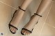 A close up of a woman's feet wearing black sandals.