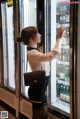 A woman standing in front of a vending machine.