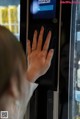 A woman is pressing a button on a vending machine.