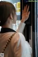 A woman in a white dress is using a vending machine.