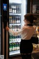 A woman standing in front of a vending machine.