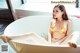 A woman in a gold bikini sitting in a bathtub.