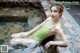 A woman in a green bathing suit sitting in a pool.