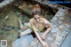 A woman in a green bathing suit sitting in a pool of water.