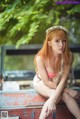 A woman in a pink bikini sitting on the back of a truck.