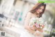 A woman in a wedding dress holding a bouquet of flowers.