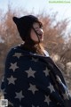 A woman wrapped in a blanket with stars on it.