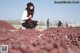 A woman sitting on top of a pile of grapes.