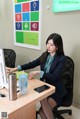 A woman sitting at a desk in front of a computer.