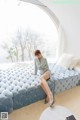 A woman sitting on a blue couch in a room.