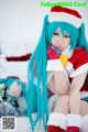 A girl in a santa outfit sitting in the snow.