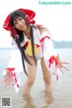 A woman in a red and white outfit standing in the water.