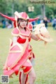 A woman dressed in a red and gold costume holding a sword.