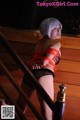 A woman in lingerie tied up to a railing.