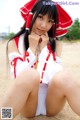 A woman in a red and white outfit sitting on the ground.