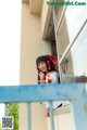 A woman in a red and white uniform is looking out of a window.