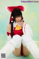 A woman in a red and white outfit sitting on the ground.