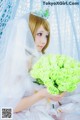 A woman in a wedding dress holding a bouquet of green roses.