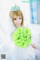 A woman in a wedding dress holding a bouquet of green roses.