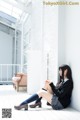 A woman sitting on the floor with her legs crossed.