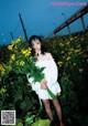 A woman standing in a field of yellow flowers.