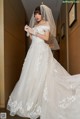 A woman in a wedding dress standing in a hallway.