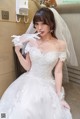 a woman in a wedding dress standing in front of a mirror