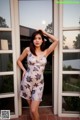 A woman standing in front of a glass door.