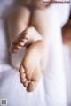 A close up of a woman's bare feet on a bed.