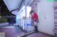 A woman in a school uniform standing in front of a vending machine.